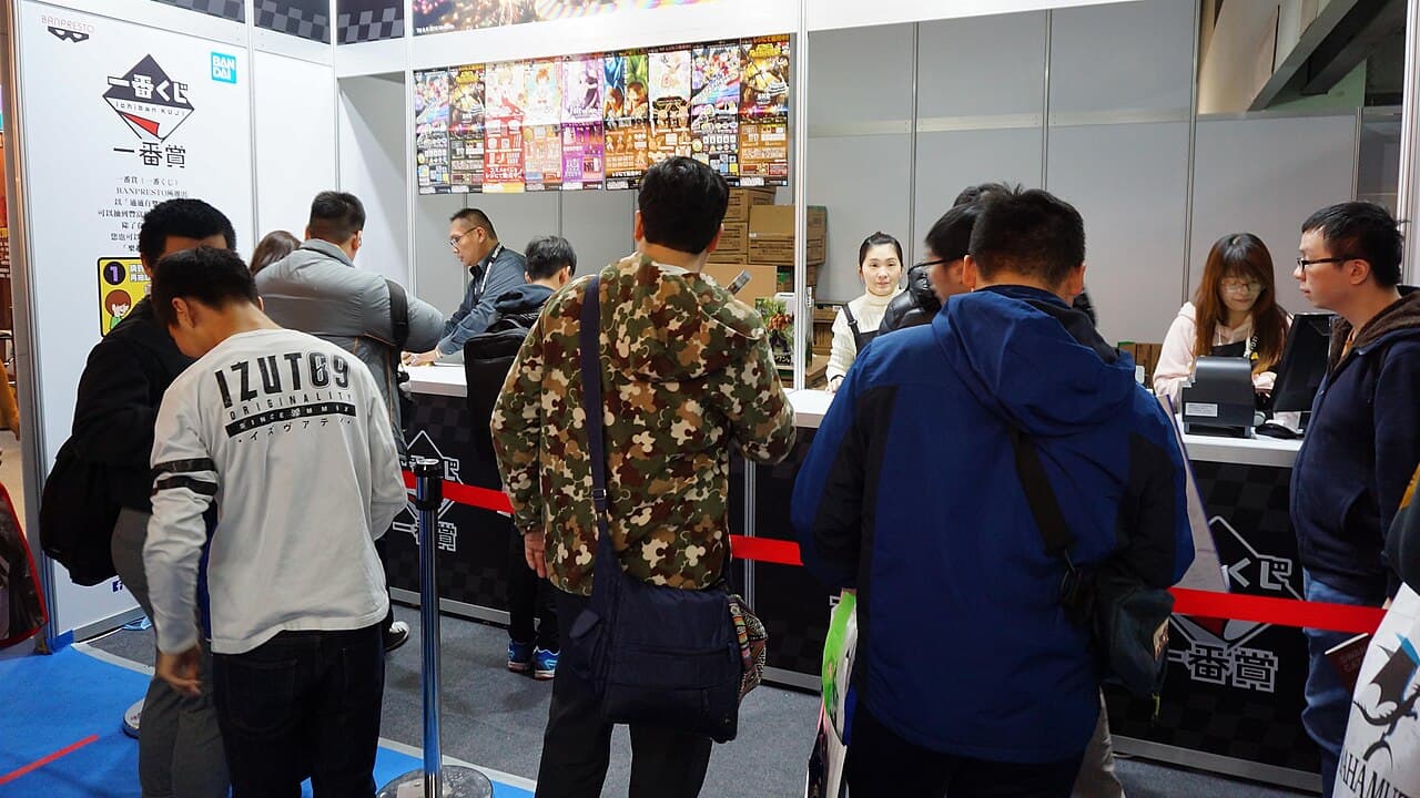 An Ichiban Kuji drawing booth and cashier counter at a convention (Taipei Game Show) — illustrating the physical box-and-ticket format the lottery uses in stores across Asia